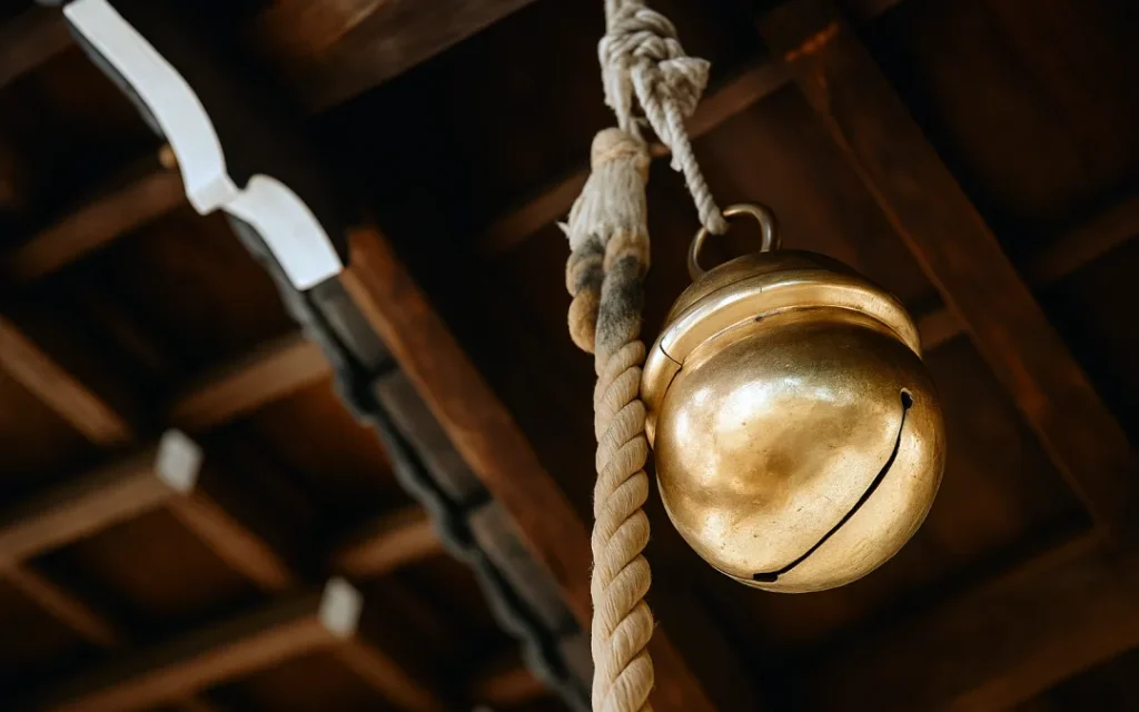 日本の神社の拝殿の軒下に吊り下げられた、深く澄んだ音色を響かせるための大きな真鍮製の本坪鈴(ほんつぼすず)の拡大写真。